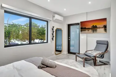 a bedroom with a bed and a chair and windows at Condo Right off Las Olas - Steps to FTL Beach 2A in Fort Lauderdale