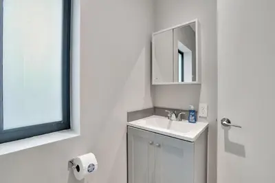 a white bathroom with a sink and a mirror at Condo Right off Las Olas Steps to FTL Beach 1A in Fort Lauderdale