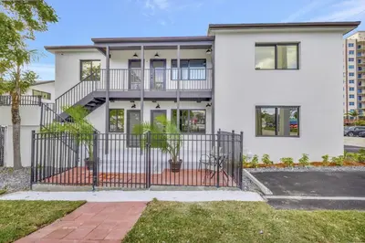 a white house with a wrought iron gate at 2 Condo Combo Walk to Beach Off Las Olas 2AB in Fort Lauderdale