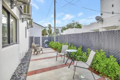 a patio with chairs and a table and a fence at 2 Condo Combo Walk to Beach Off Las Olas 2AB in Fort Lauderdale