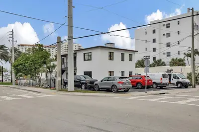 a parking lot with cars parked in front of a building at Studio Right off Las Olas - Steps to FTL Beach 1B in Fort Lauderdale