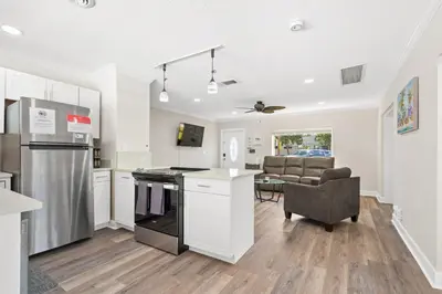 a kitchen and living room with a stove and a couch at Wills off Wilton Drive 2 bed and 1 bath plus Den with Heated Pool in Fort Lauderdale