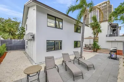 a patio with chairs and a table in front of a house at Lux Villa 3br 2ba off Las Olas in Fort Lauderdale