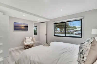 a white bedroom with a large bed and a chair at Lux Villa 3br 2ba off Las Olas in Fort Lauderdale