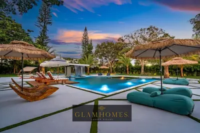 a swimming pool with chairs and umbrellas at Sunny Isles Beach Luxury Property by Glam Homes in Miami