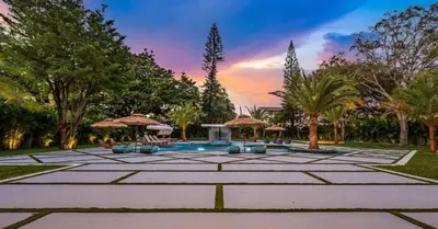 a large courtyard with a pool and trees at Sunny Isles Beach Luxury Property by Glam Homes in Miami