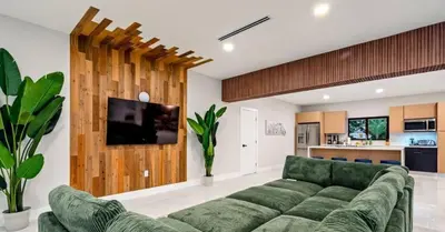 a living room with a green couch and a kitchen at Sunny Isles Beach Luxury Property by Glam Homes in Miami