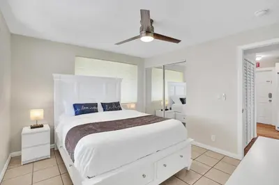 a white bedroom with a bed and a ceiling fan at Beach Condo - Hollywood Beachfront and Broadwalk in Hollywood