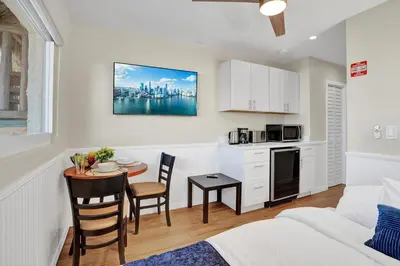 a living room with a couch and a table and a kitchen at Beach Efficiency - Hollywood Beachfront and Broadwalk in Hollywood