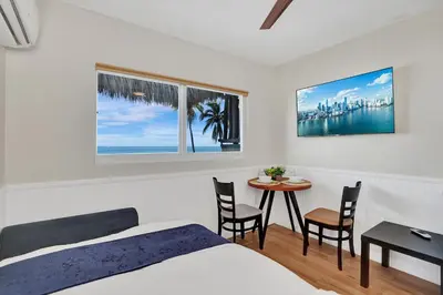 a bedroom with a bed and a table and chairs at Beach Efficiency - Hollywood Beachfront and Broadwalk in Hollywood