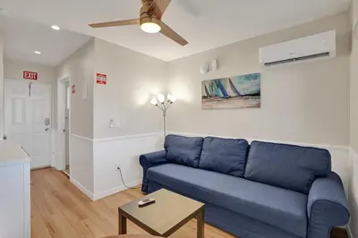 a living room with a blue couch and a ceiling fan at Beach Efficiency - Hollywood Beachfront and Broadwalk in Hollywood