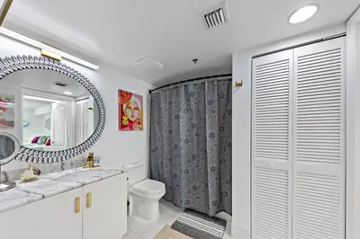 a bathroom with a sink and a toilet and a mirror at Oceanside Penthouse Apartment in Brickell Miami, Pool, Free Parking in Miami