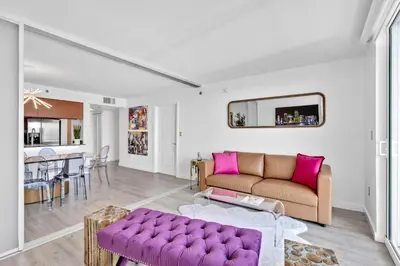 a living room with a purple couch and a table at Oceanside Penthouse Apartment in Brickell Miami, Pool, Free Parking in Miami