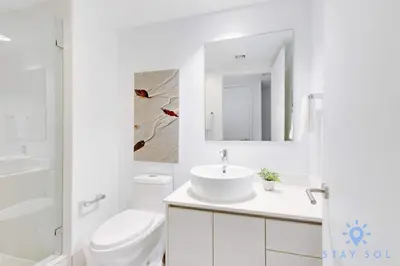 a white bathroom with a sink and a toilet at Modern Resort Retreat Steps from the Beach in Hallandale Beach