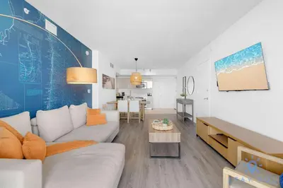 a living room with a couch and a table at Modern Resort Retreat Steps from the Beach in Hallandale Beach