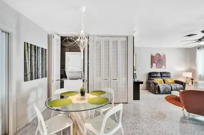 a dining room with a glass table and chairs at Heated pool, parking, 5 min walk to food and fun! in Fort Lauderdale