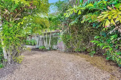 a backyard with a fence and some trees at Heated pool, parking, 5 min walk to food and fun! in Fort Lauderdale