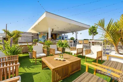 a patio with wooden tables and chairs on the grass at Amazing Pool - Hot Tub - Gym - Near Beach in Hollywood