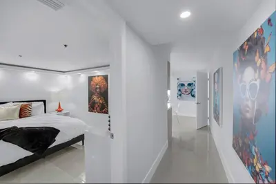 a bedroom with a bed and some pictures on the wall at Shades of Miami Sky Penthouse! Newly Renovated in Miami