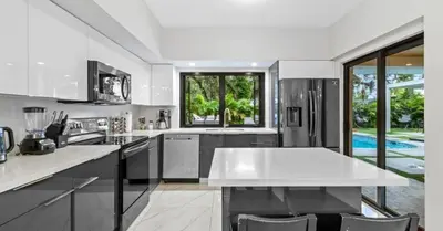 a large white kitchen with a large white counter top at Entertaining Villa Fun Games Mini Golf Grill in Miami