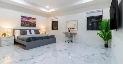 a bedroom with a king sized bed and marble floors at Tropical Villa wJacuzzi Big Terrace & Billiards in Miami