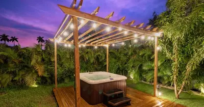 a wooden pergola with a bath tub in a garden at Tropical Villa wJacuzzi Big Terrace & Billiards in Miami