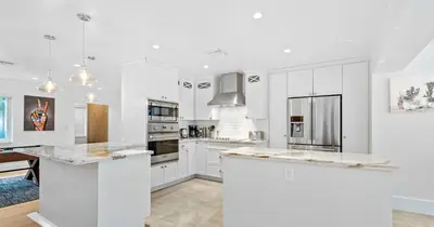 a kitchen with white cabinets and a large island at New Hidden Gem in Miami