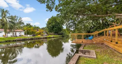 a wooden bridge over a river with a house at New Hidden Gem in Miami