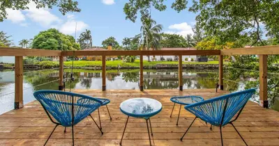 two blue chairs and a glass table on a wooden deck at New Hidden Gem in Miami