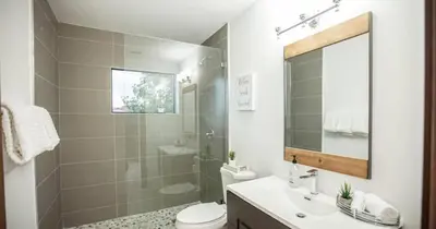 a bathroom with a sink and a toilet and a mirror at Luxurious Retreat with Tennis and Soccer Courts TGH in Miami