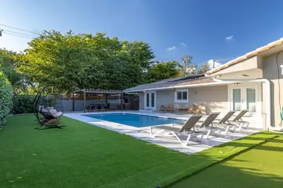 a backyard with a swimming pool and lawn at Villa w/a Huge Terrace & Grill Mini Golf Pool in Miami