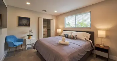 a bedroom with a bed and a blue chair at Villa Athena - The Glamhomes in Miami