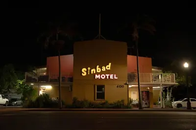 a building with a sign that reads studied motel at night at Sinbad Motel in Miami