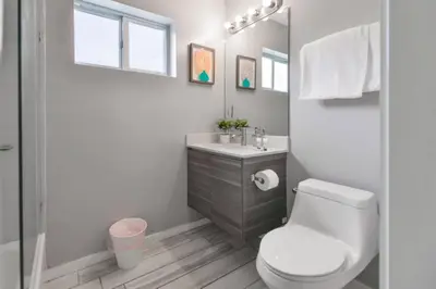 a bathroom with a toilet and a sink and a mirror at Wynwood Amazing Condo Sleeps 5 Close to Beach in Miami