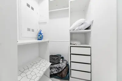 a walk in closet with white walls and white shelves at Wynwood Amazing Condo Sleeps 5 Close to Beach in Miami