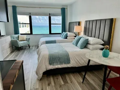 a large bedroom with two beds and a living room at Directly on the Beach with Pool & Ocean View in Miami Beach