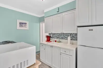 a kitchen with white cabinets and a white refrigerator at Panoramic beachfront Suite in Hollywood