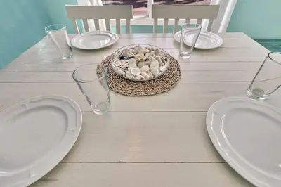 a table with plates and glasses and a bowl of shells at Panoramic beachfront Suite in Hollywood