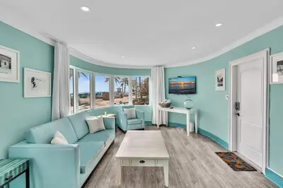 a living room with a blue couch and a table at Panoramic beachfront Suite in Hollywood