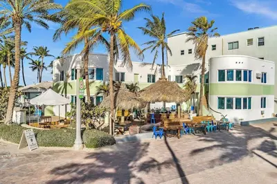 a resort with palm trees and tables and chairs at Panoramic beachfront Suite in Hollywood