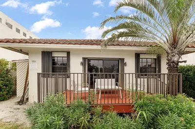 a house with a palm tree and a porch at DOWNTOWN LAS OLAS WATERFRONT HOME UPDATED UNIT in Fort Lauderdale