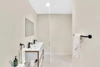 a white bathroom with a sink and a shower at 1 bedroom tropical pool house in Hallandale Beach