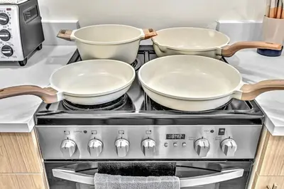three pots and pans on top of a stove in a kitchen at 1 bedroom tropical pool house in Hallandale Beach