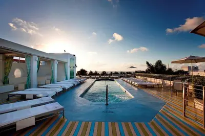 a large swimming pool with white lounge chairs at CasaGrandeSouthBeach by AmericanVacationLiving 6BR in Miami Beach