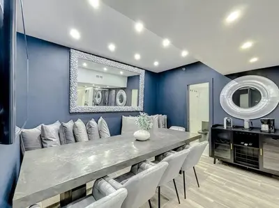 a dining room with a long table and white chairs at CasaGrandeSouthBeach by AmericanVacationLiving 6BR in Miami Beach