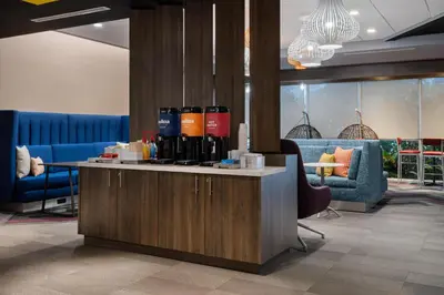a lobby with a counter with wine bottles on it at Tru By Hilton Miramar in Miramar