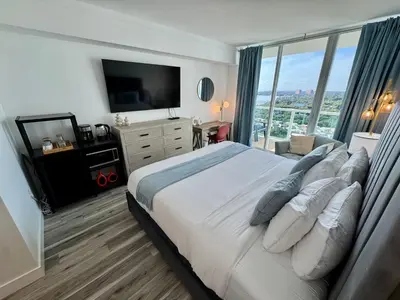 a bedroom with a large bed with a large window at Balcony Ocean View ! Pool - WiFi - Gym - Parking in Miami