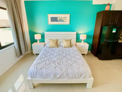 a bedroom with a white bed and blue walls at Directly on the Beach with Pool & Ocean View in Miami Beach