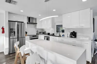 a kitchen with white cabinets and a large white counter top at Gorgeous poolhome on the canal in Fort Lauderdale