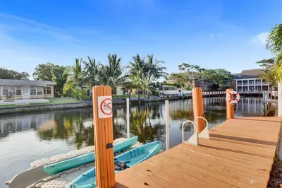 a dock with boats on a body of water at Gorgeous poolhome on the canal in Fort Lauderdale